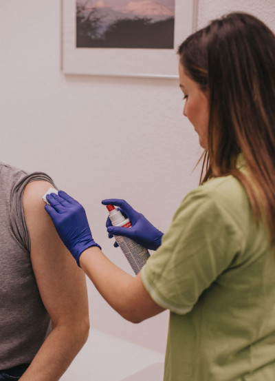 Bild 06 - Mitarbeiterin desinfiziert Patientenarm.jpg